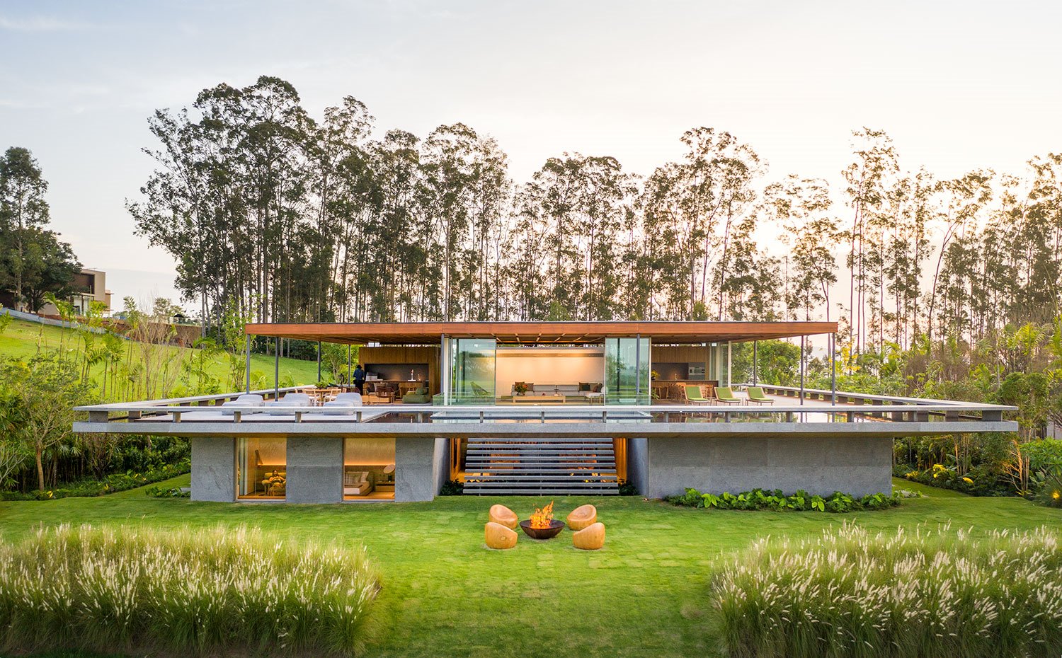 Vista exterior vivienda con las dos plantas a la vista, rodeada de zona ajardinada