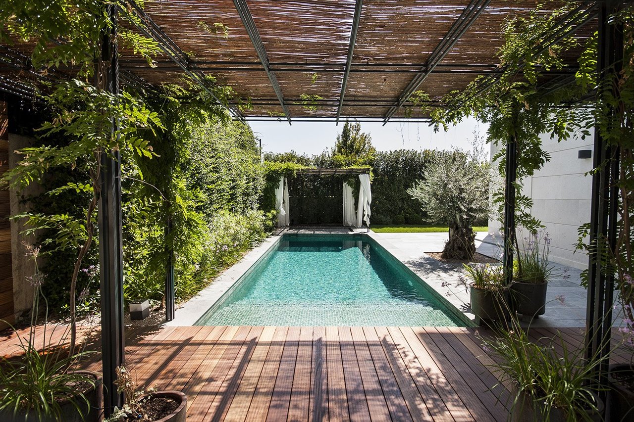 Pérgola de cañizo y tarima de madera en un jardín en Aravaca (Madrid), de Dstudio.