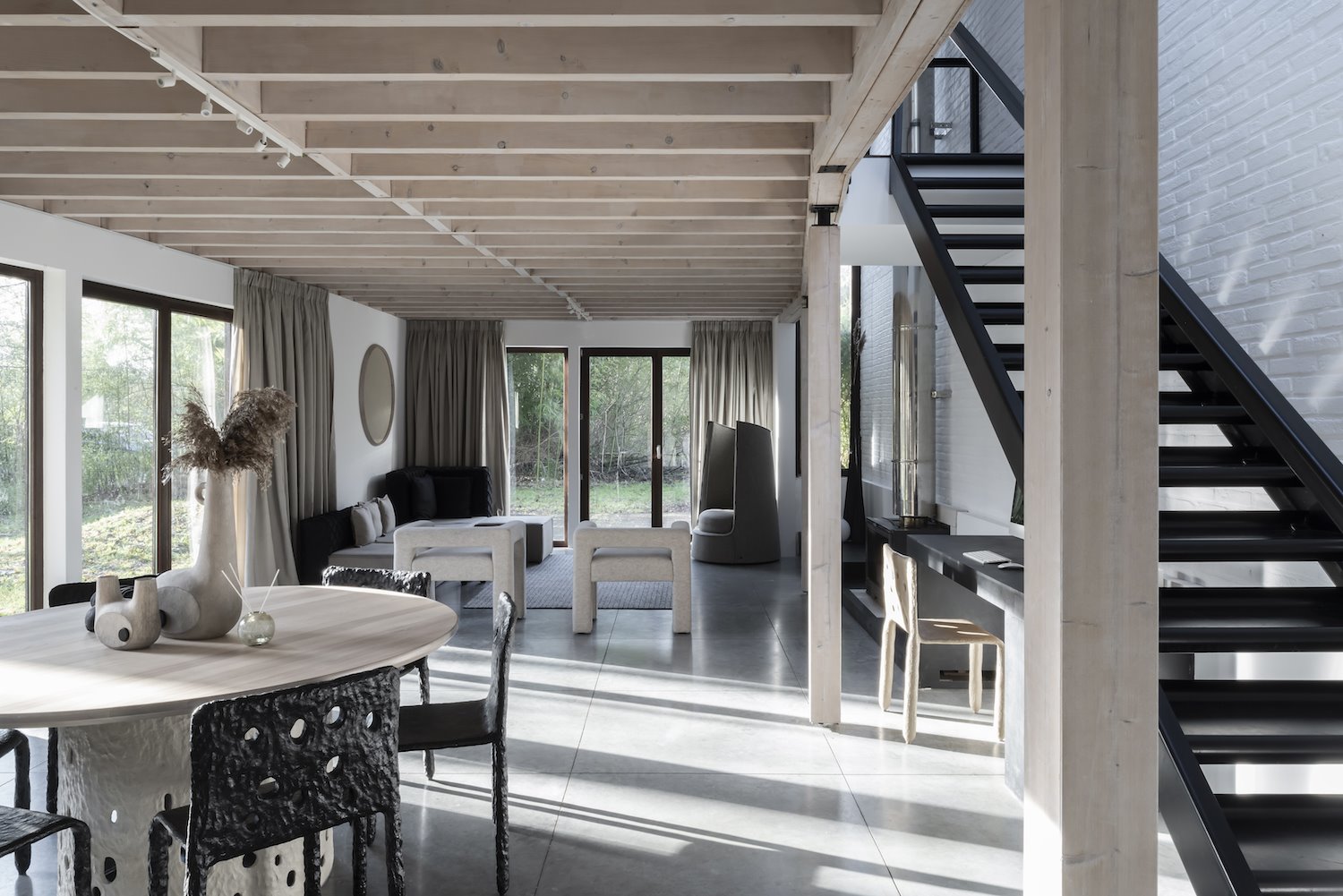 Comedor y escalera de una moderna casa con vigas de madera