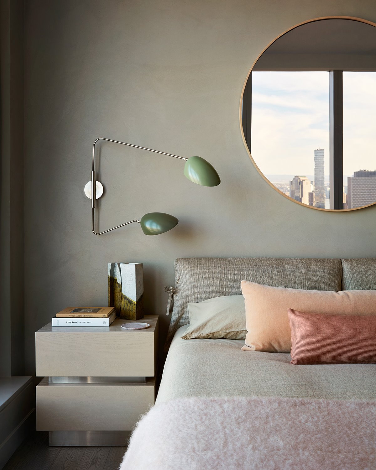 Dormitorio con espejo circular de una casa diseñada por Jamie Bush