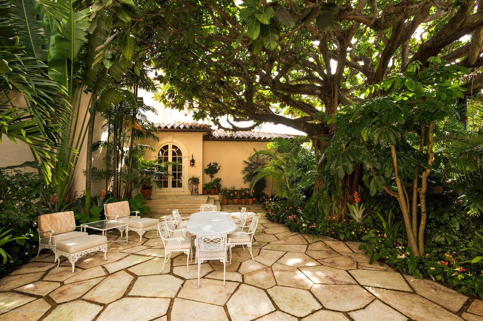 Jardín con muebles de hierro blancos de la casa de los Kennedy en Palm Beach