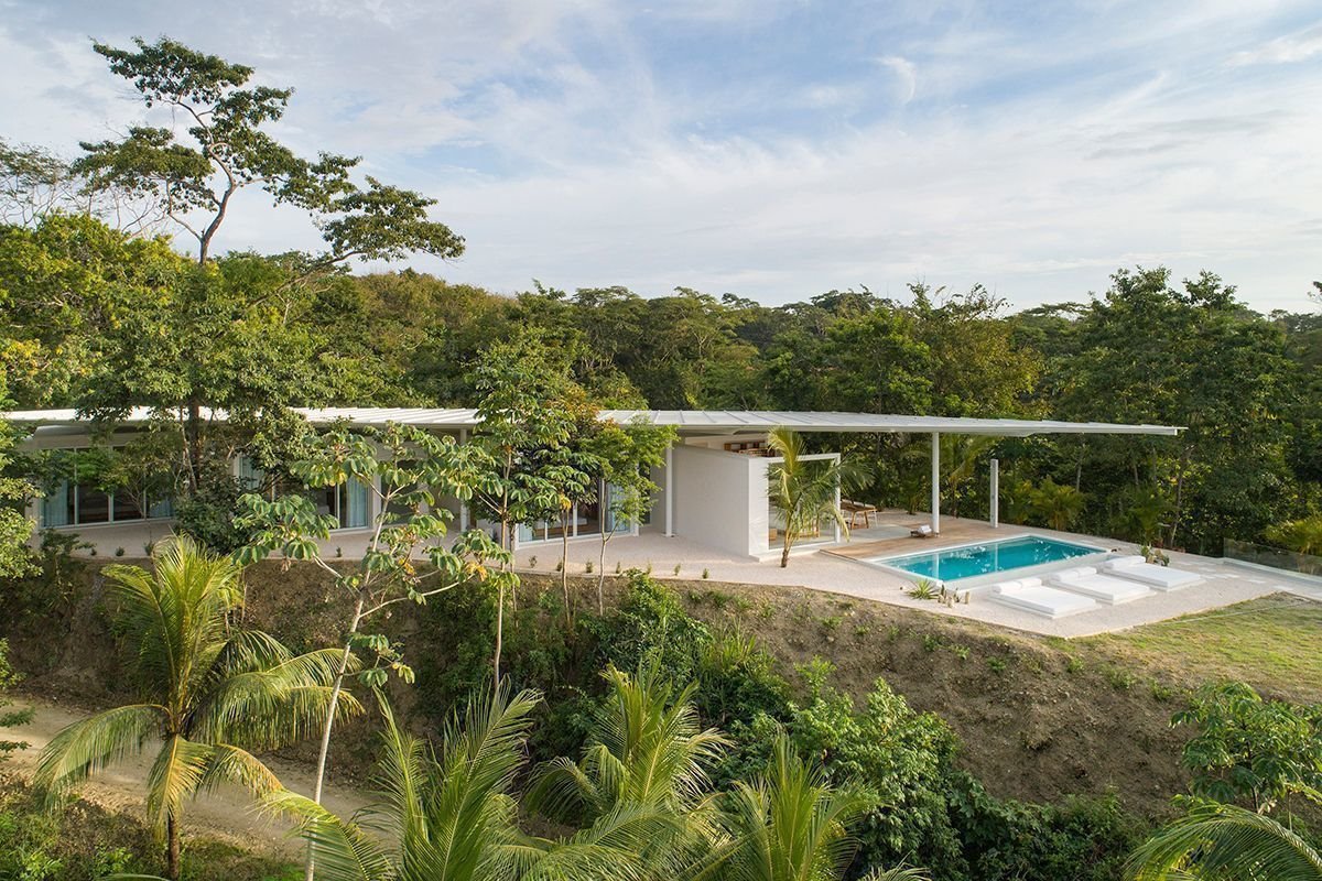 Casa prefabricada de color blanco en costa rica con piscina en mitad de la selva