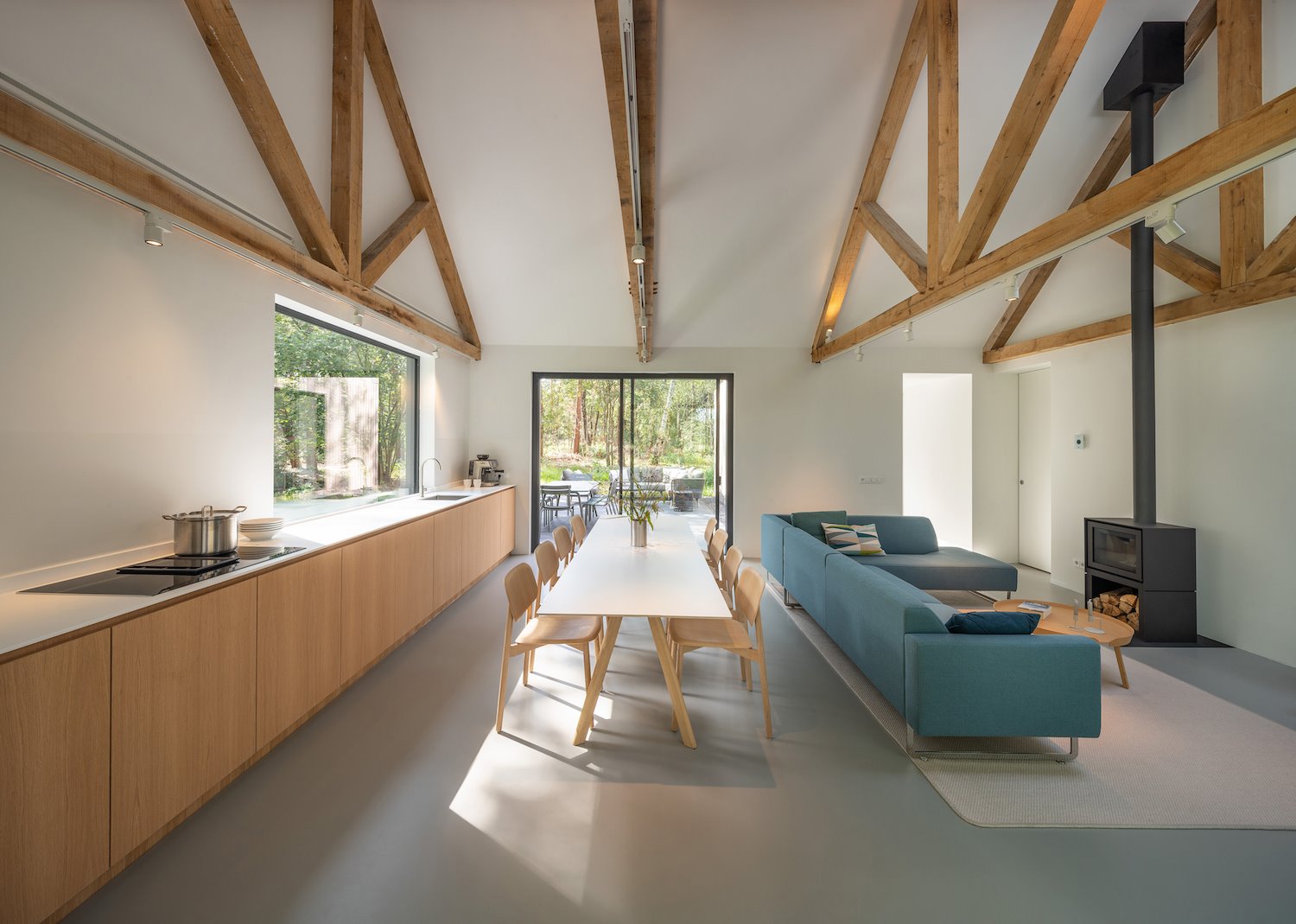 Salon con vigas de madera y cocina integrada