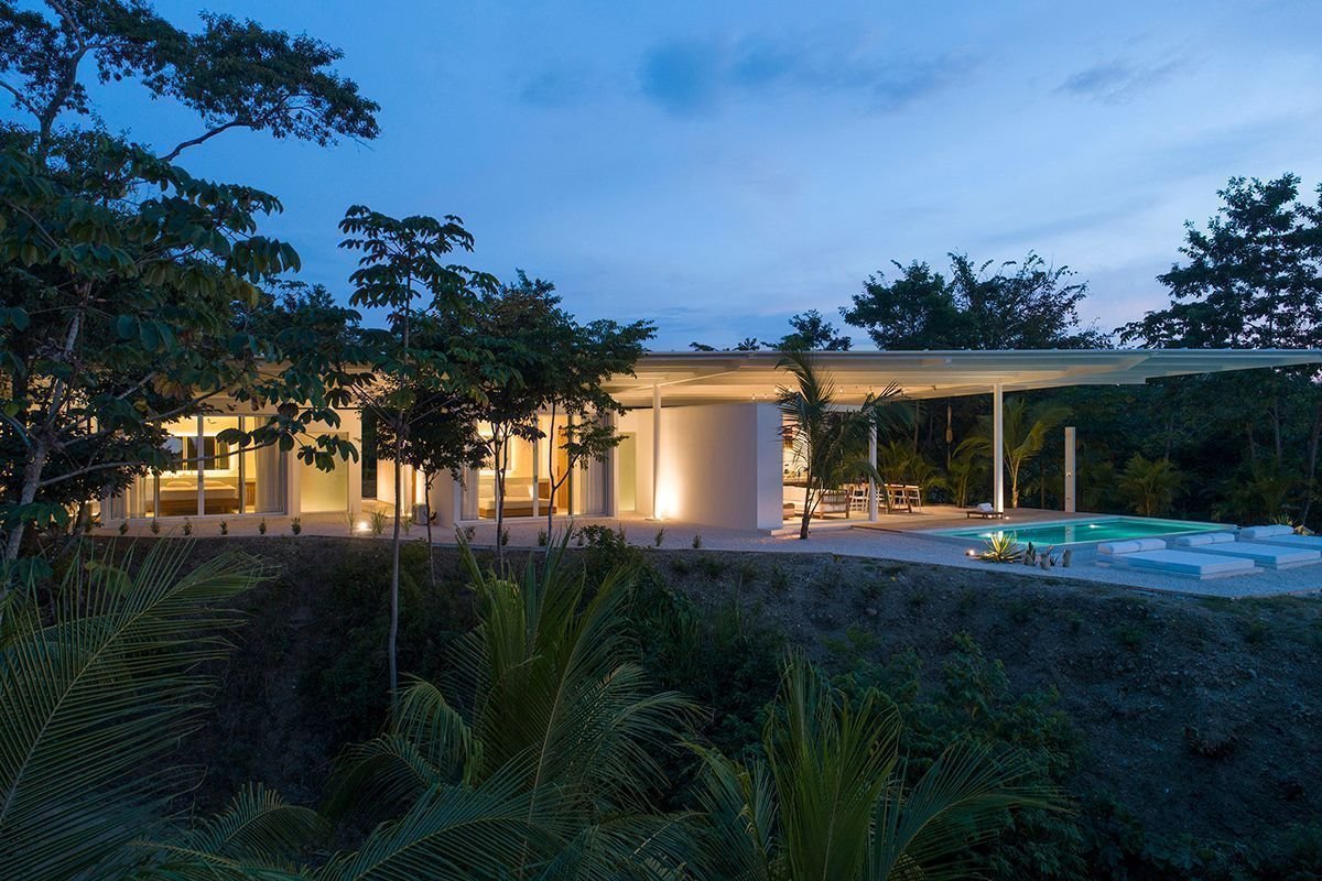Vista de noche de una Casa prefabricada de color blanco en costa rica