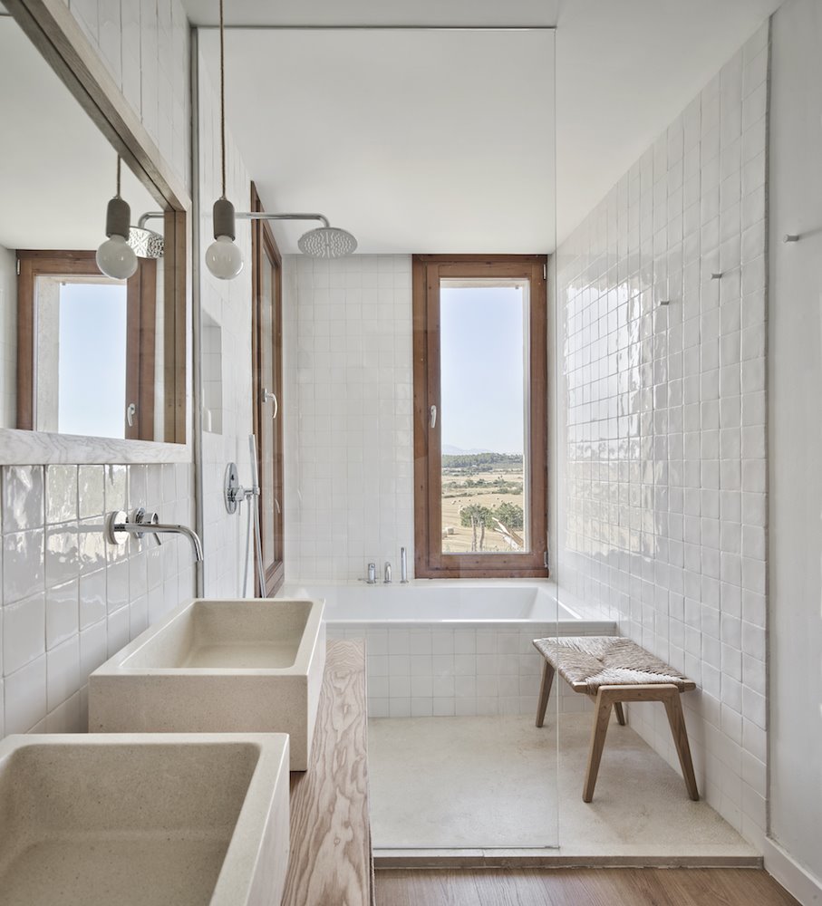 Baño con azulejos blancos Casa en Mallorca del estudio de arquitectura OHLAB