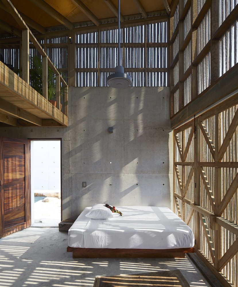 Dormitorio de una casa con paredes de hormigñon