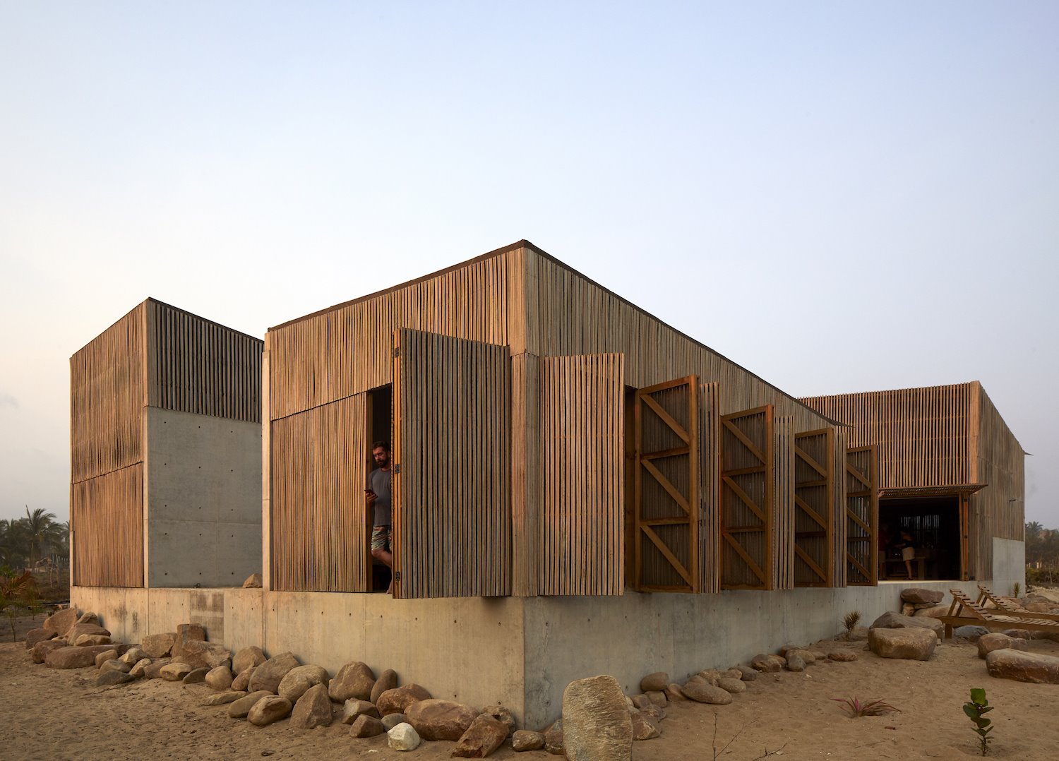 Fachada con puertas plegables de madera y hormigón en Mexico
