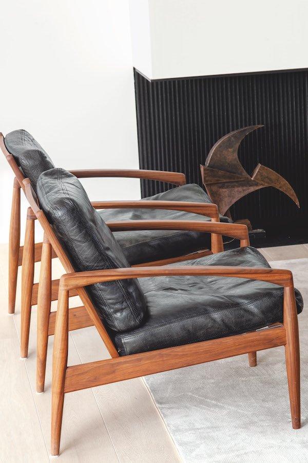 Butacas de piel negra y madera