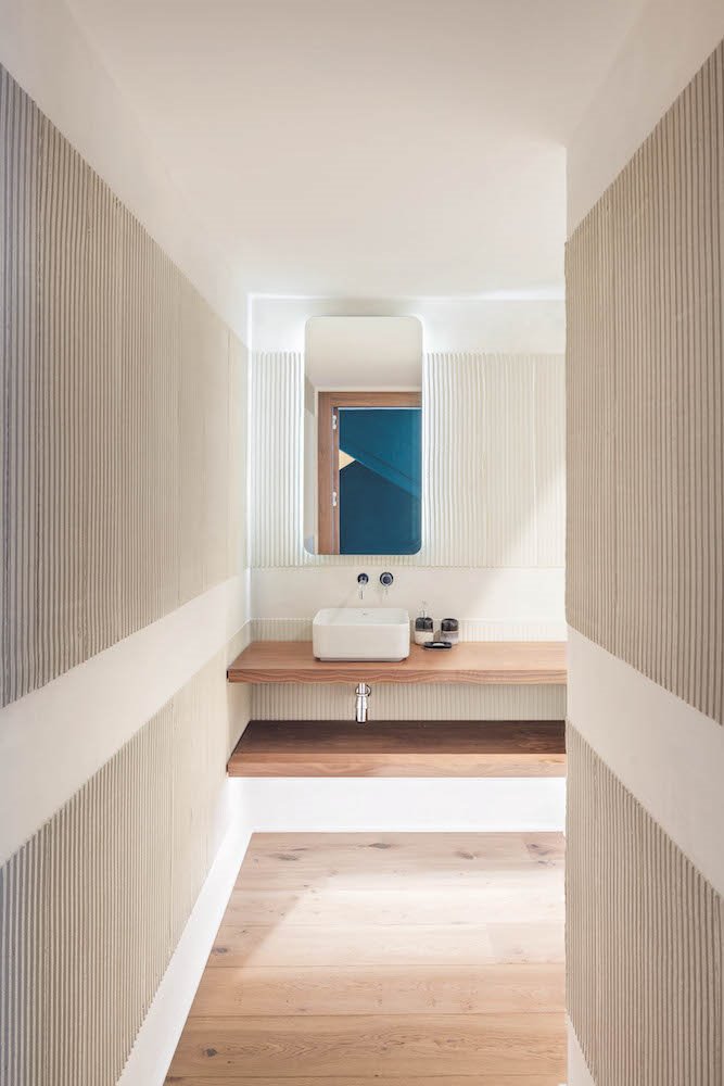 Baño con paredes con textura y espejo rectangular