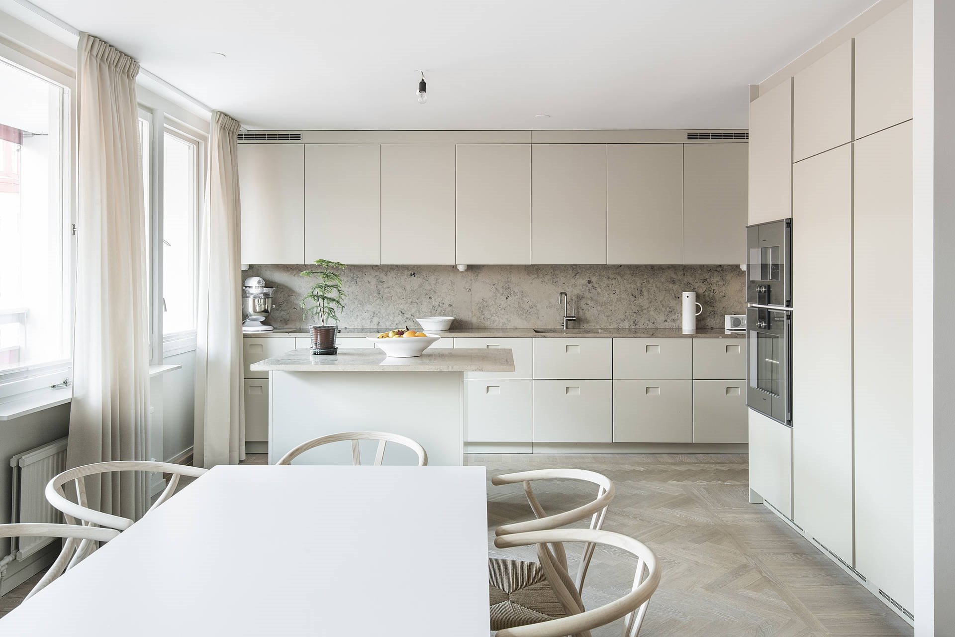 Cocina con muebles de color blanco y mesa de comedor