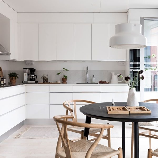 Cocina con muebles de color blanco y mesa redonda