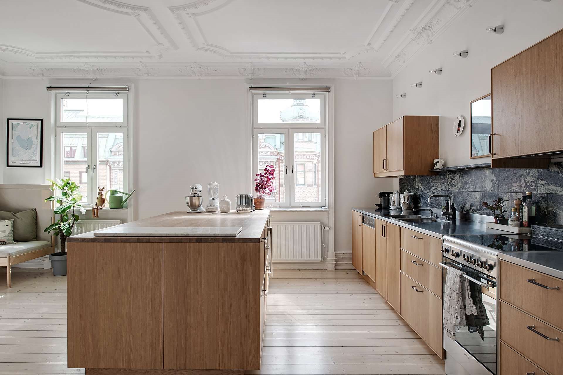 Cocina con muebles de madera y molduras en el techo