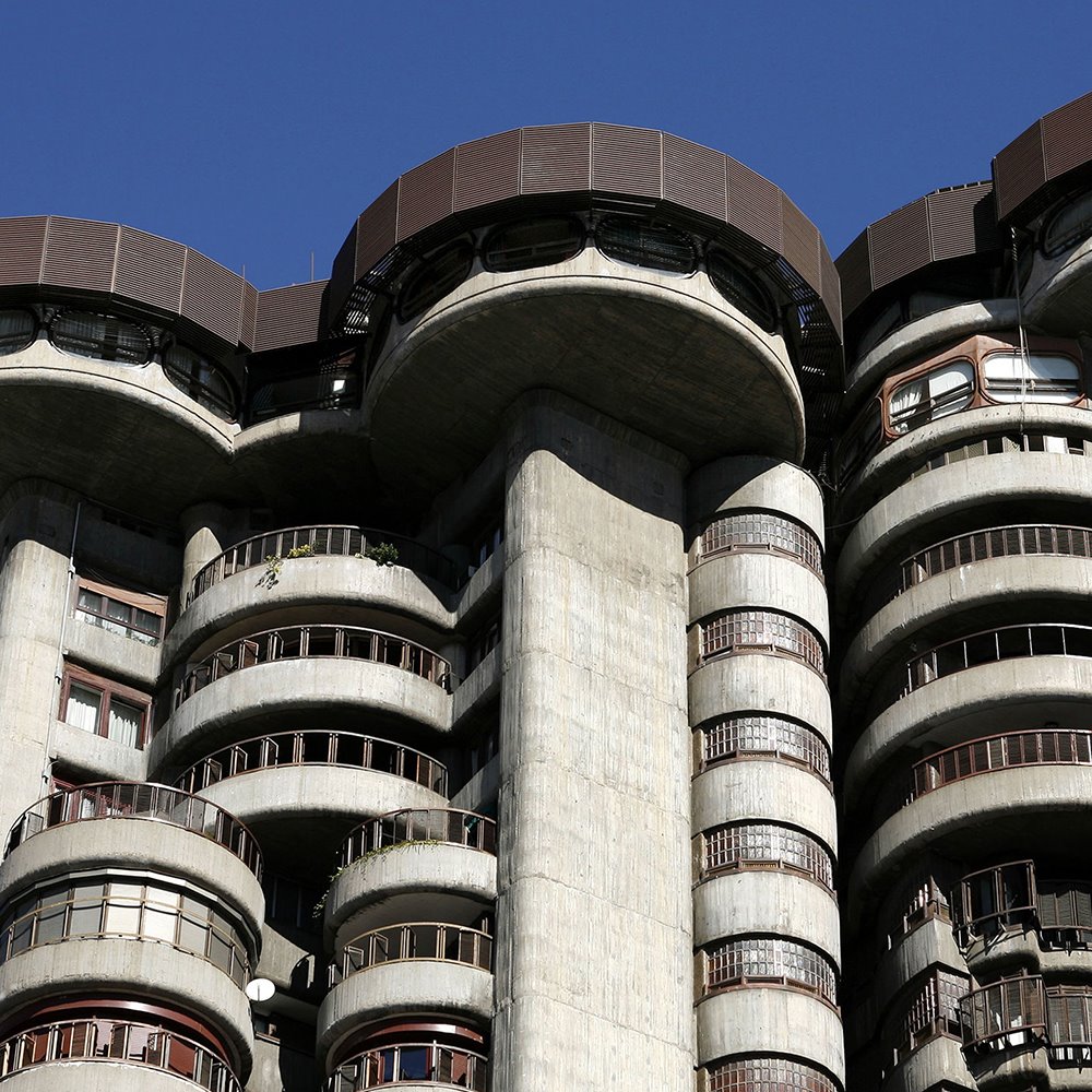 La crudeza del hormigón exterior es moderado por el uso de pantallas de filigrana de madera en los balcones, que varían en su posición relativa en la cara de la fachada exterior.