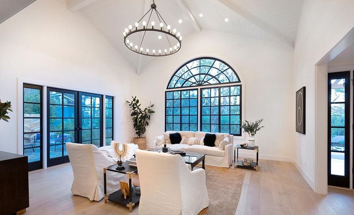 Salon con grandes ventanales y sofá blano de la nueva casa de Miley Cyrus