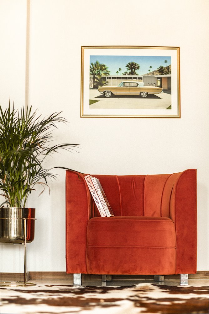 Sillón de terciopelo rojo con cuadro de un coche clásico de Danny Hellard.