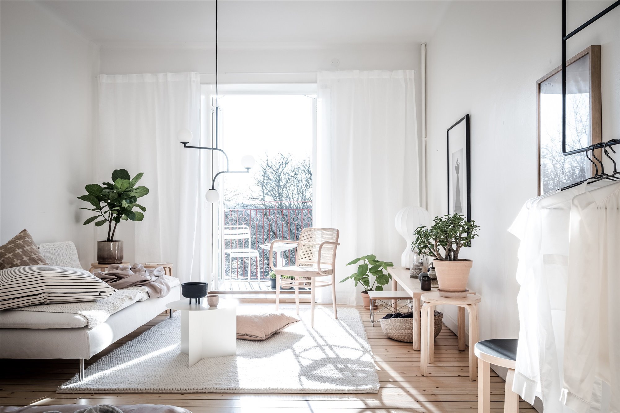 Salon con ventana y cortinas balncas lleno de luz natural