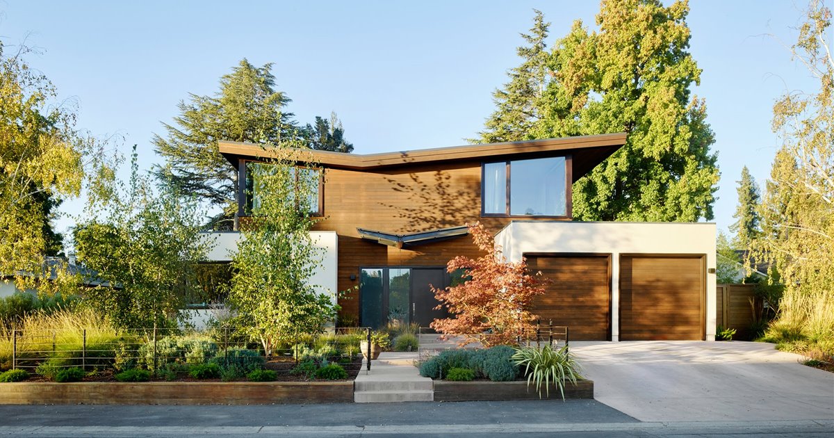 Una casa moderna con dos fachadas una de cristal y otra de madera