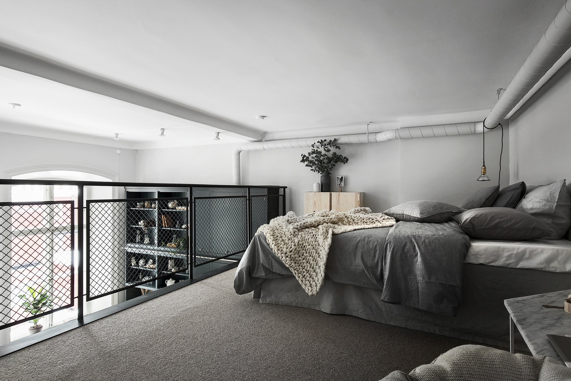 Dormitorio en doble altura en un loft de estilo industrial