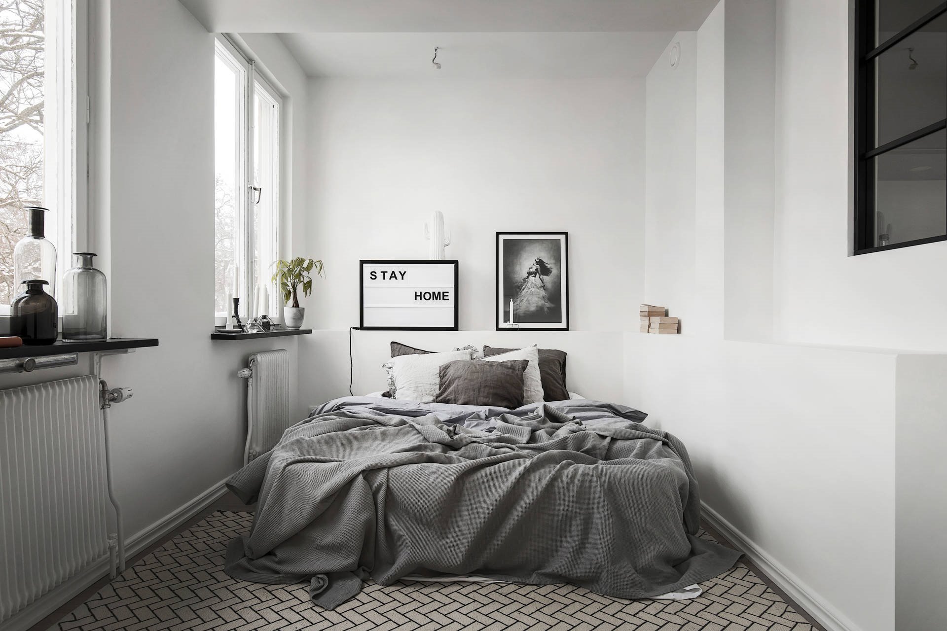 Cama king size doble con ropa de cama de color blanca y dormitorio con radiadores