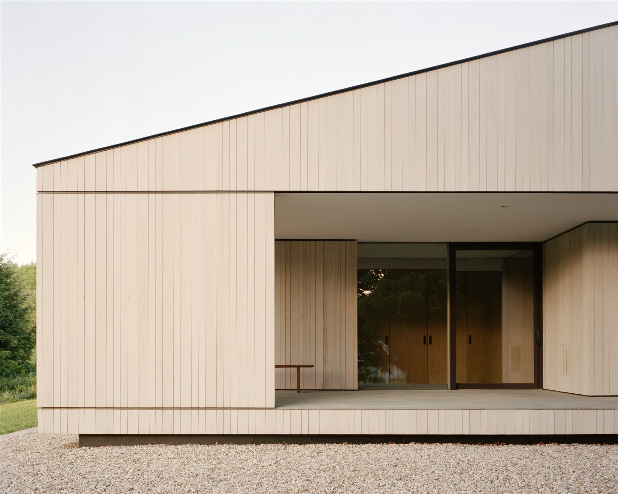 Casa con techo inclinado y fachada de madera