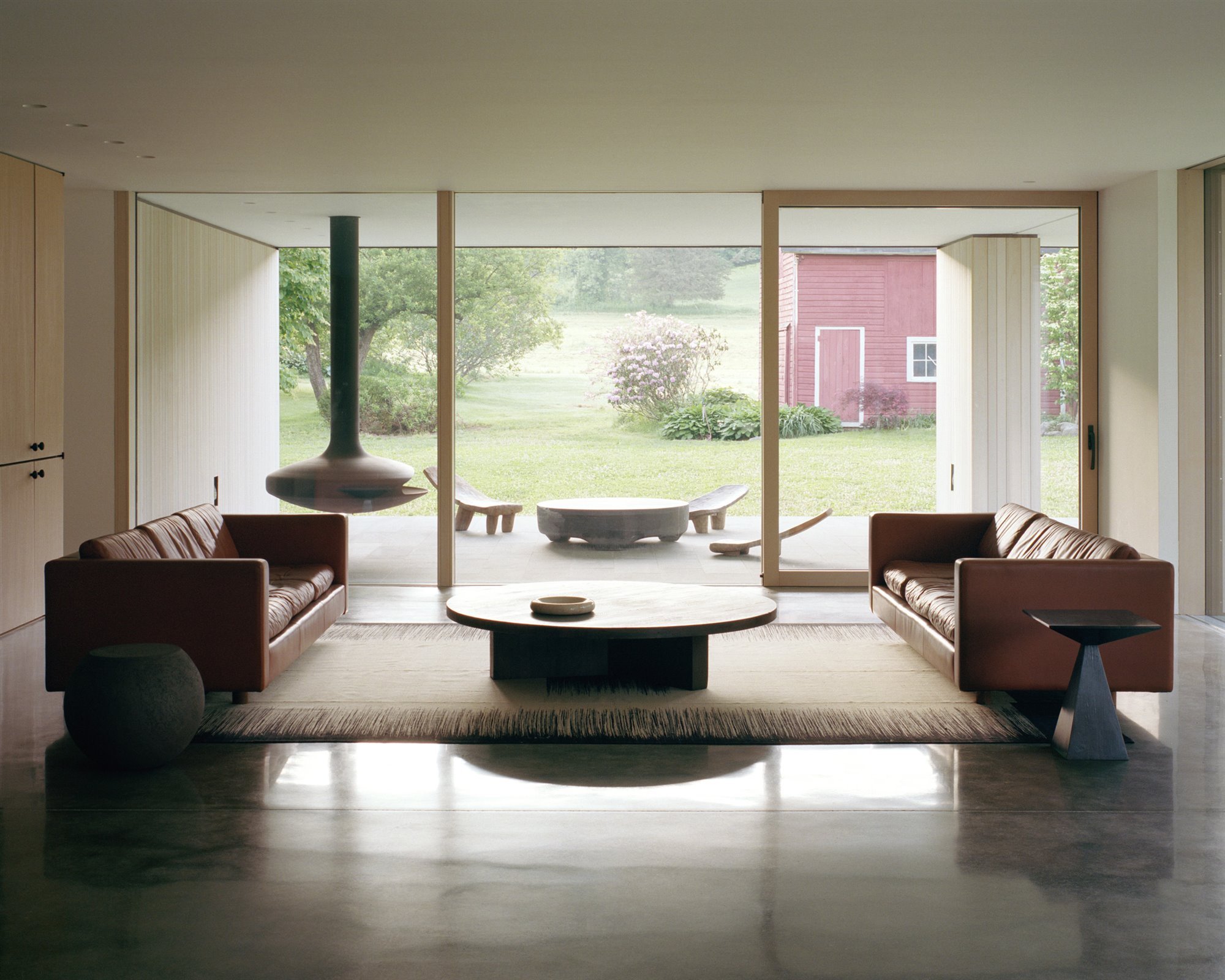 Salon con sofas de piel marron y mesa de centro redonda