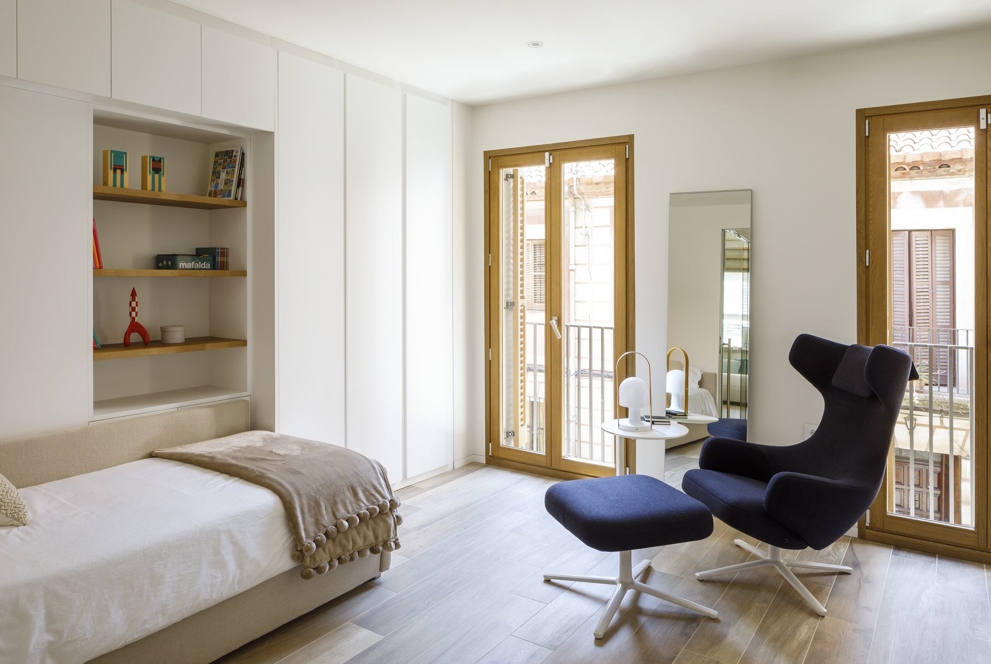 Dormitorio infantil con estanteria en la pared