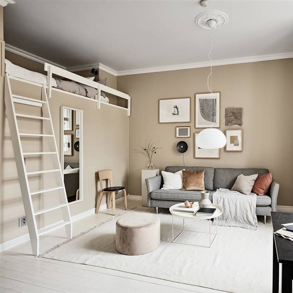 Salon con doble altura escalera con paredes en color beige ocre