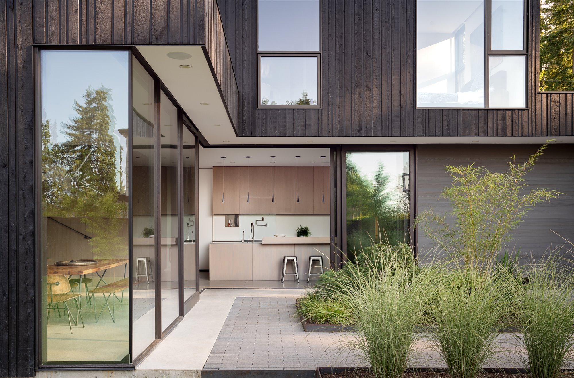 Cocina abierta a un patio casa moderna con fachada de madera