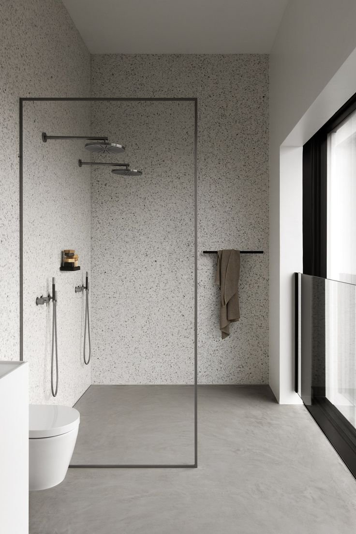 Baño con mampara de ducha y paredes de granito