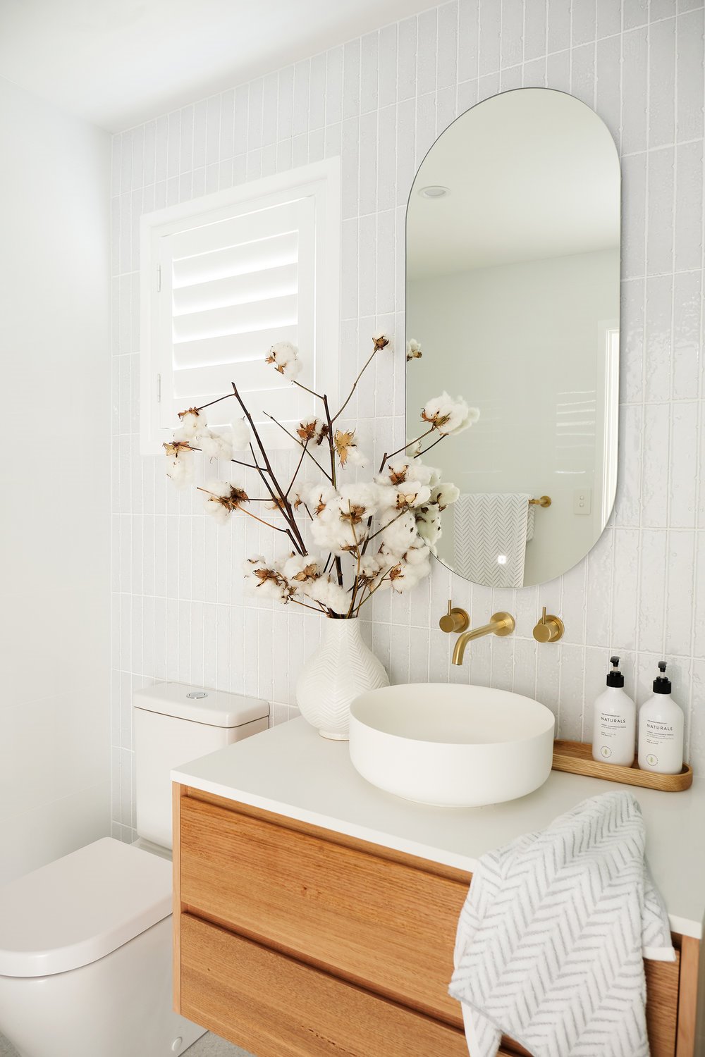 Baño con mueble de madera de ikea y lavamanos redondo
