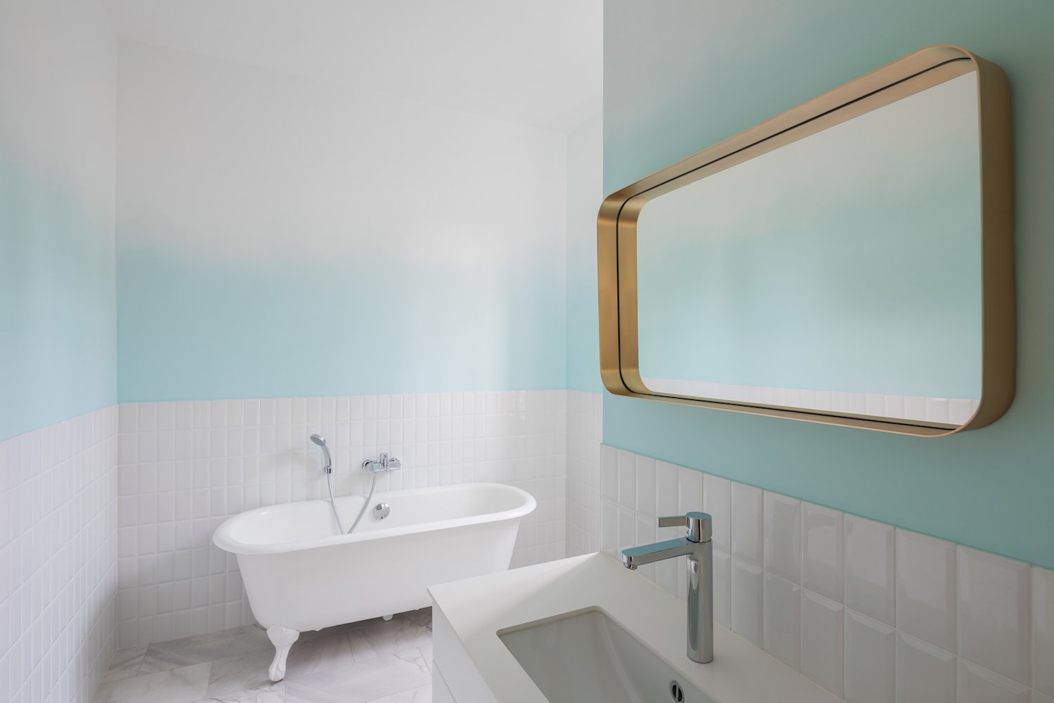 Baño con bañera y paredes en color azul turquesa