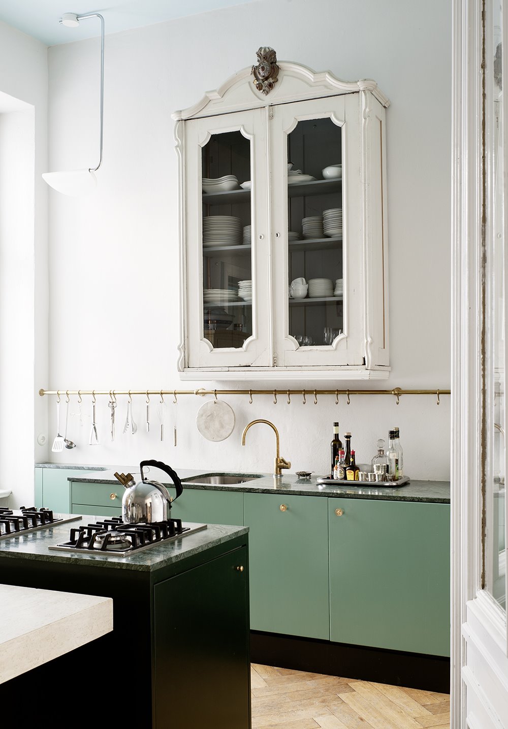 Cocina con muebles de color verde alacena de color blanco