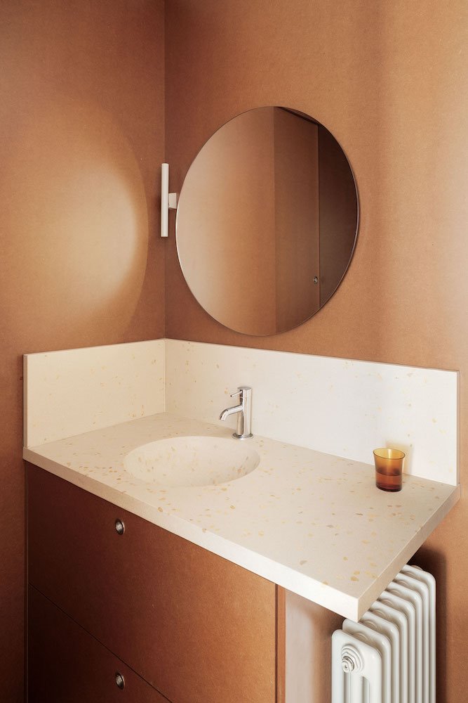 Piso en Barcelona conBaño con encimera de terrazo de color blanco y espejo redondo