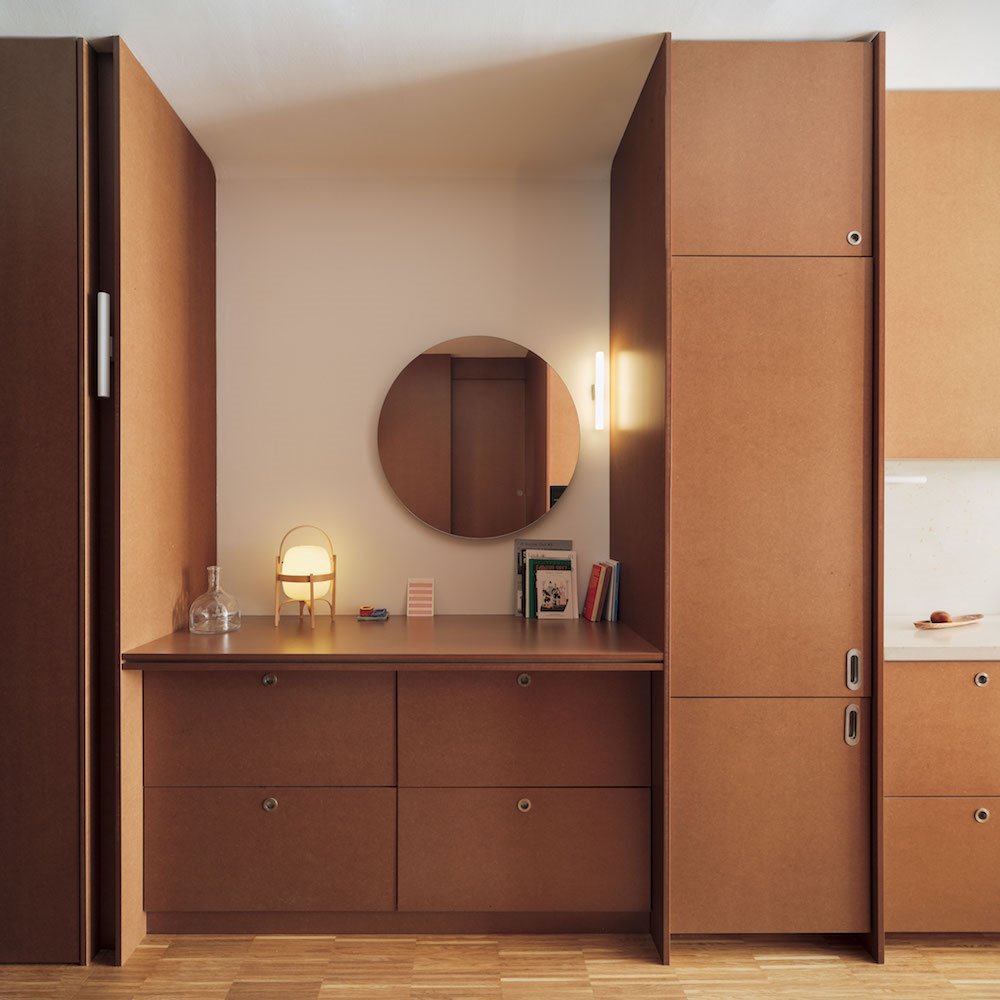 Piso en Barcelona conEmtrada mueble de madera hecho a medida con espejo redondo