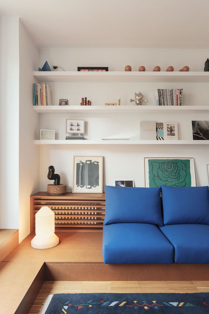 Piso en Barcelona conSalon con sofa hecho a medida con cojines de color azul y lampara de cuarzo