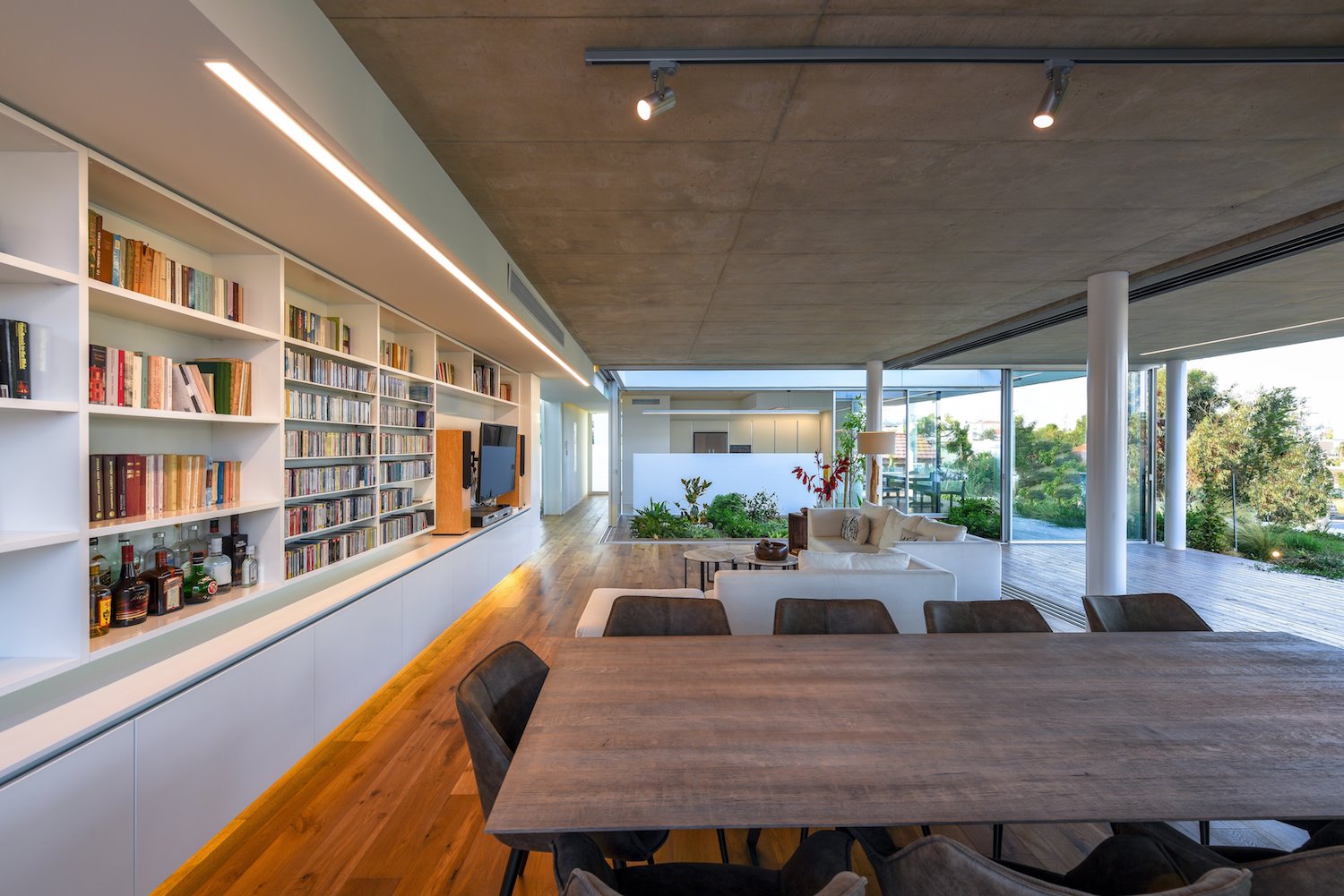 Salon con estanterias hechas a medida y suelo de madera