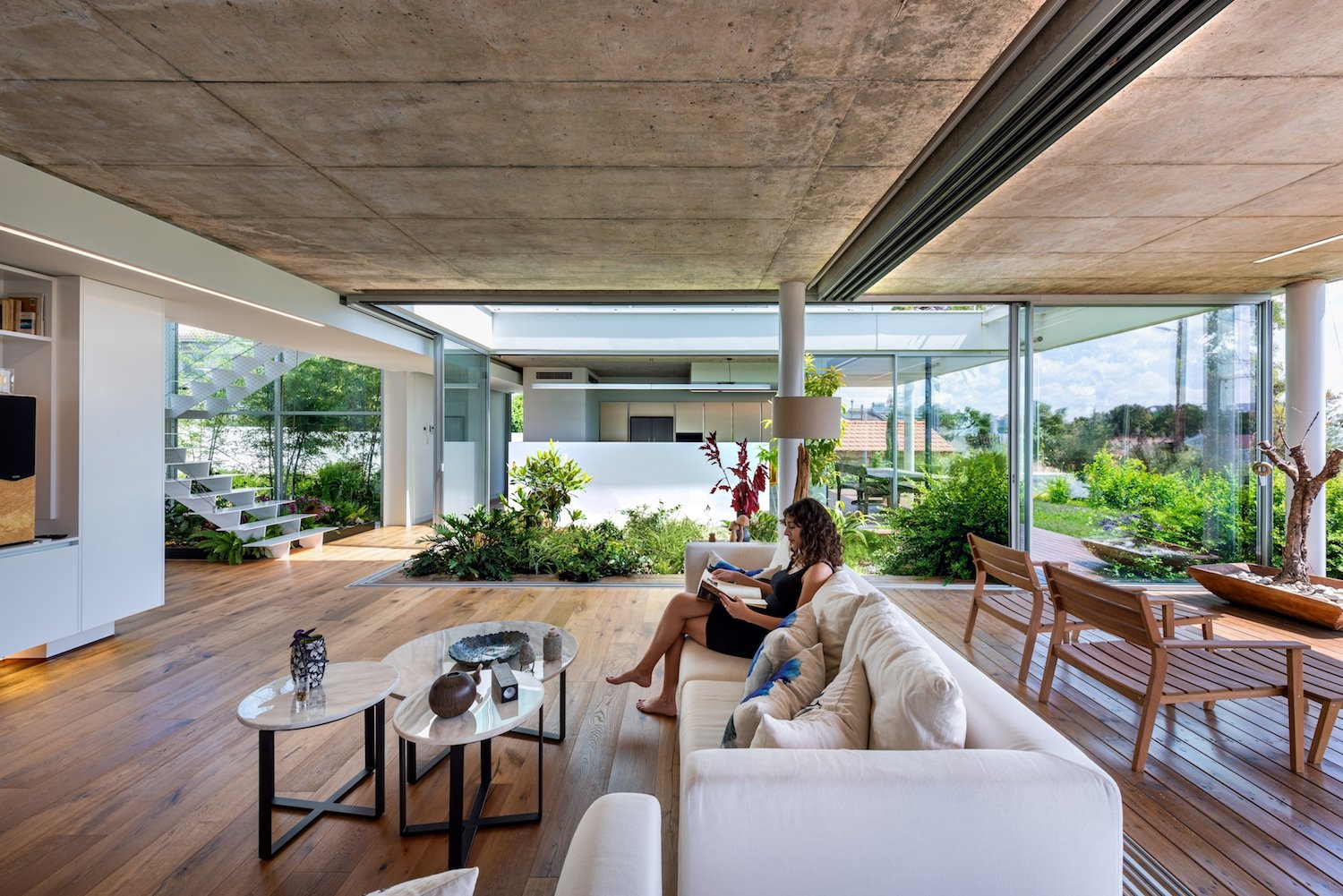 Salon con mujer leyendo suelos de madera casa moderna