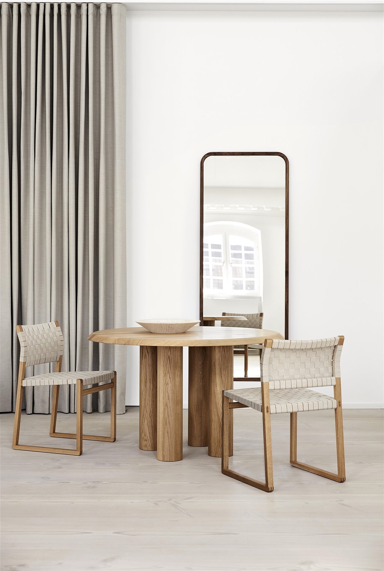Mesa de madera y sillas con téjdo trenzado.