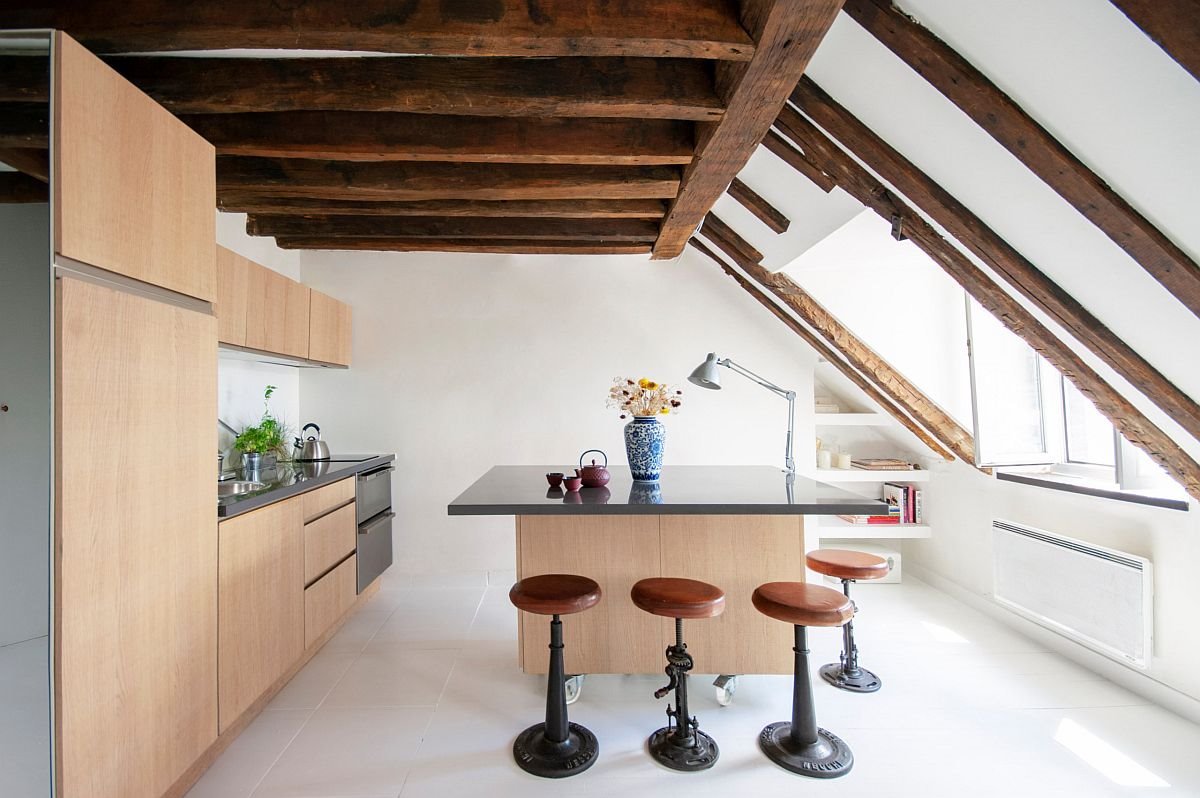 Cocina con techo con vigas de madera y barra con taburetes de cuero