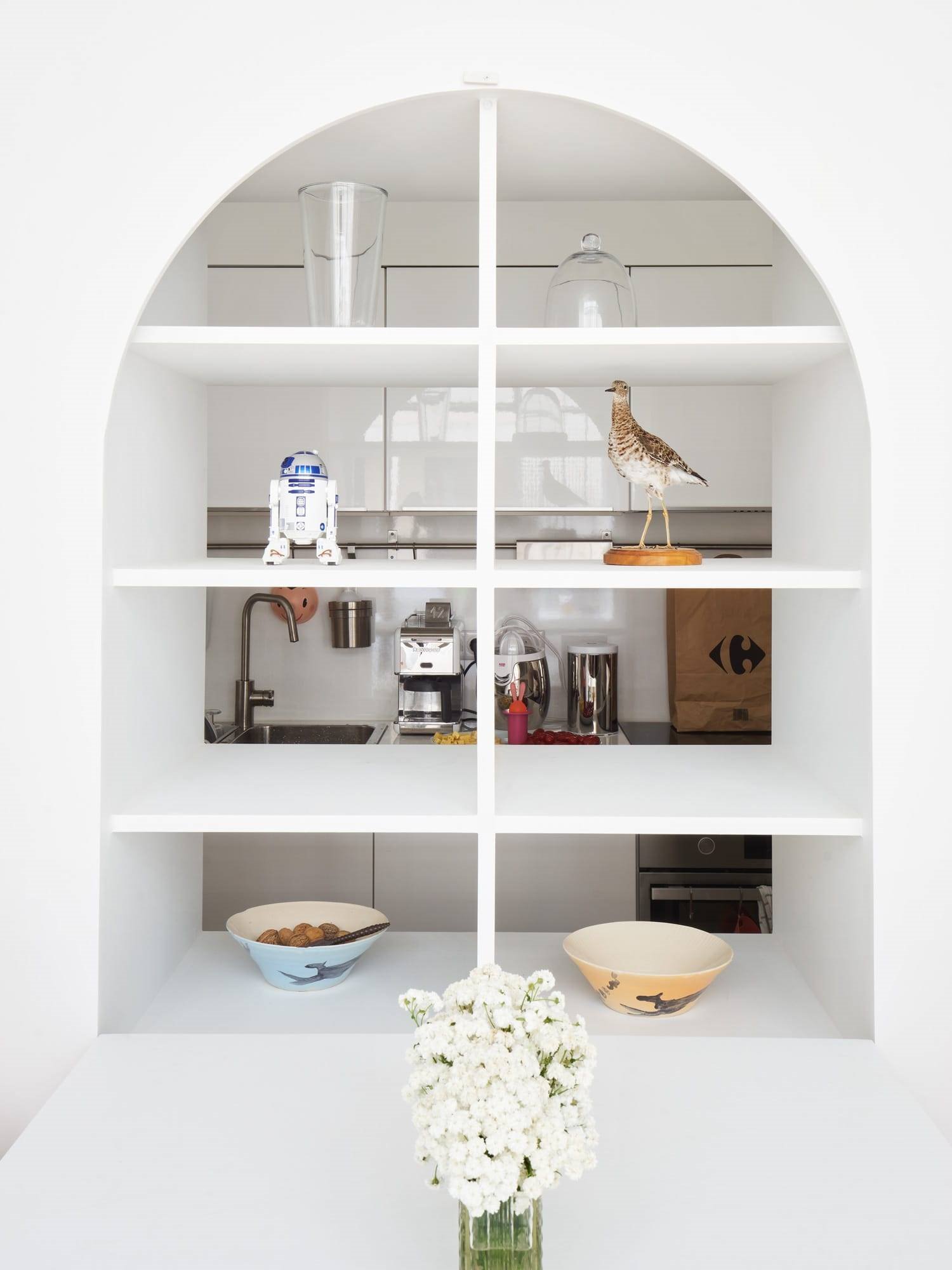 Estantería hecha a medida en forma de arco que separa el comedor de la cocina
