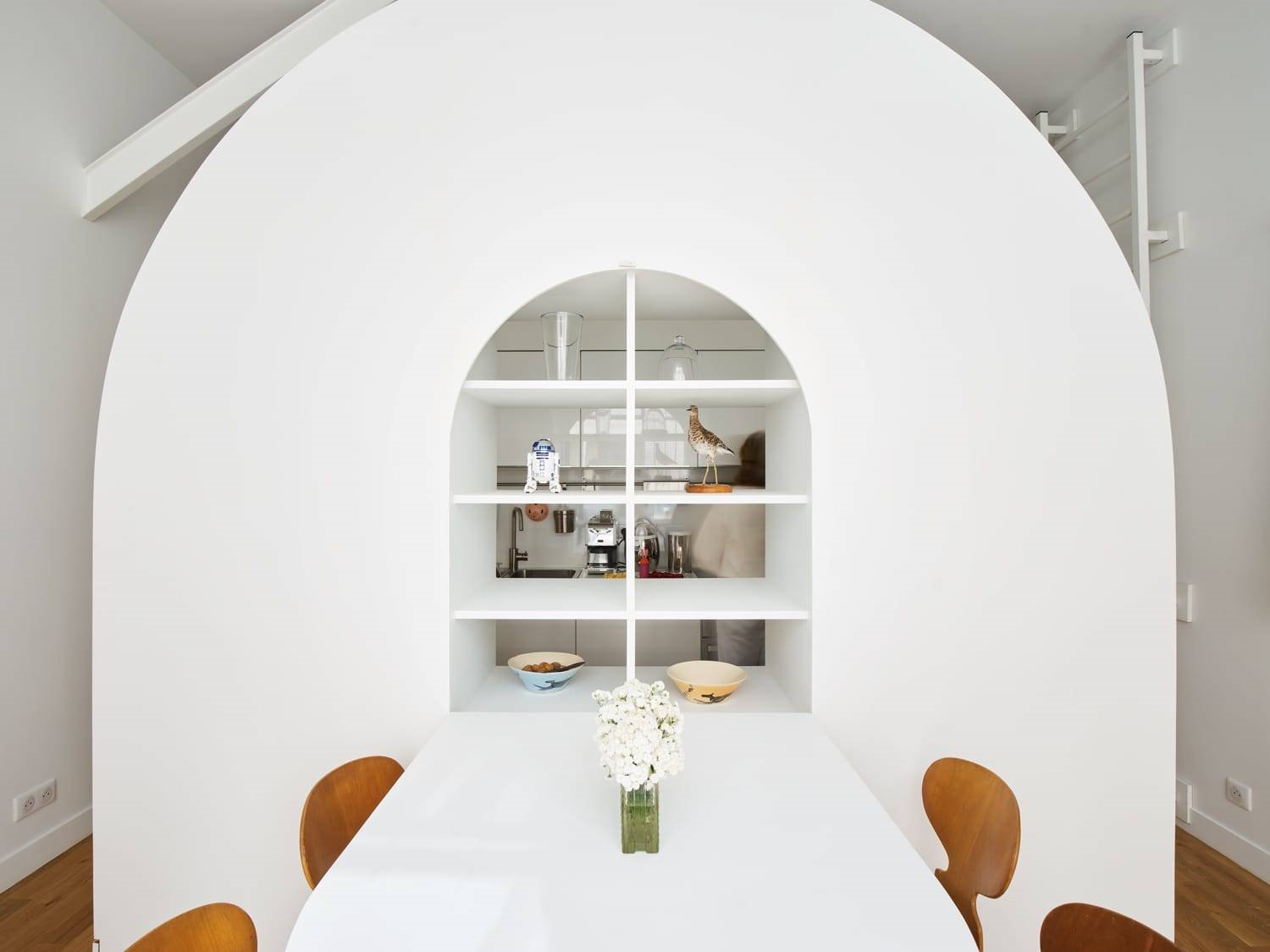 Mueble hecho a medida en forma de arco con mesa plegable y estanteria de color blanco