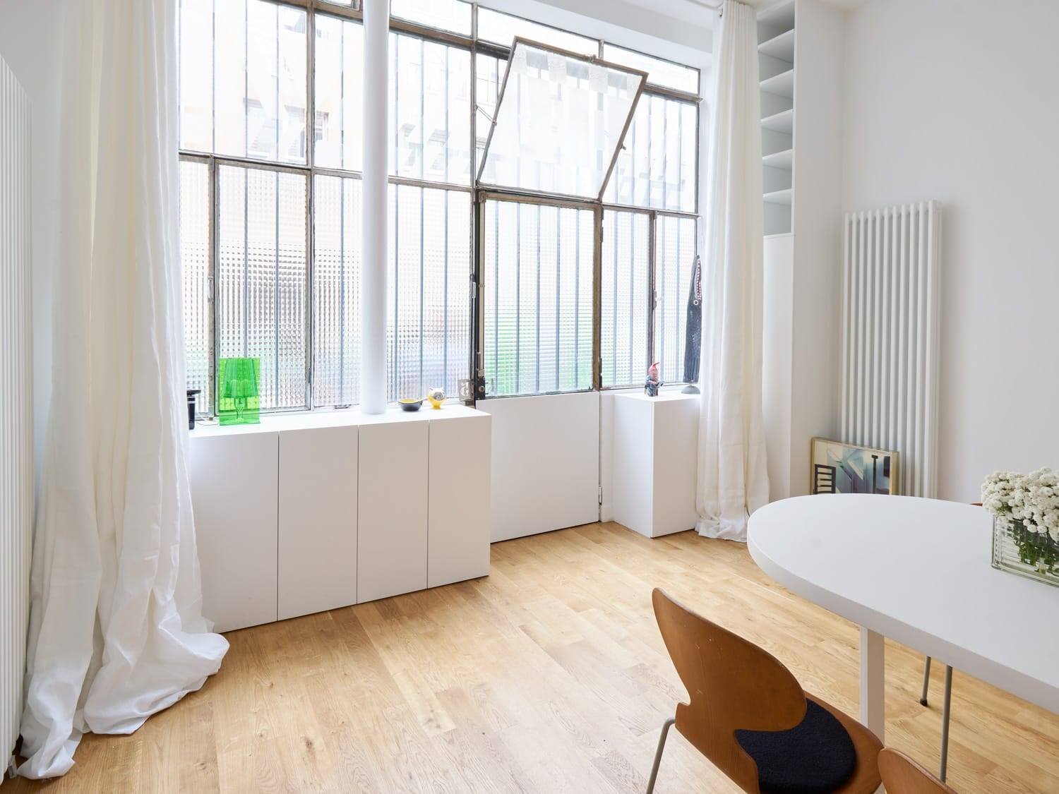 Salon con paredes de cristal ventana practiclable mesa blanca