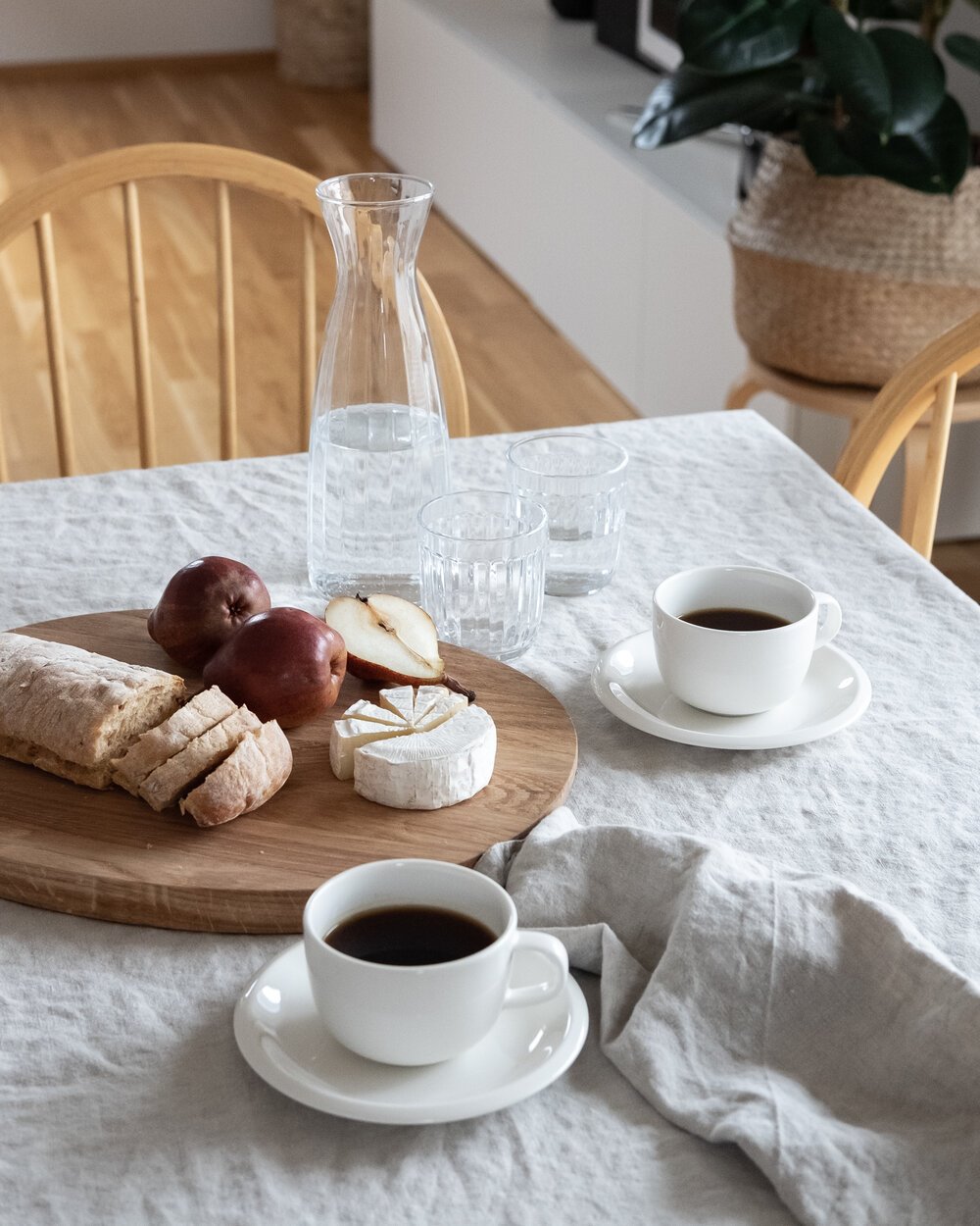 Mesa de desayuno cafe tazas blancas mantel de lino blanco y tabla de quesos