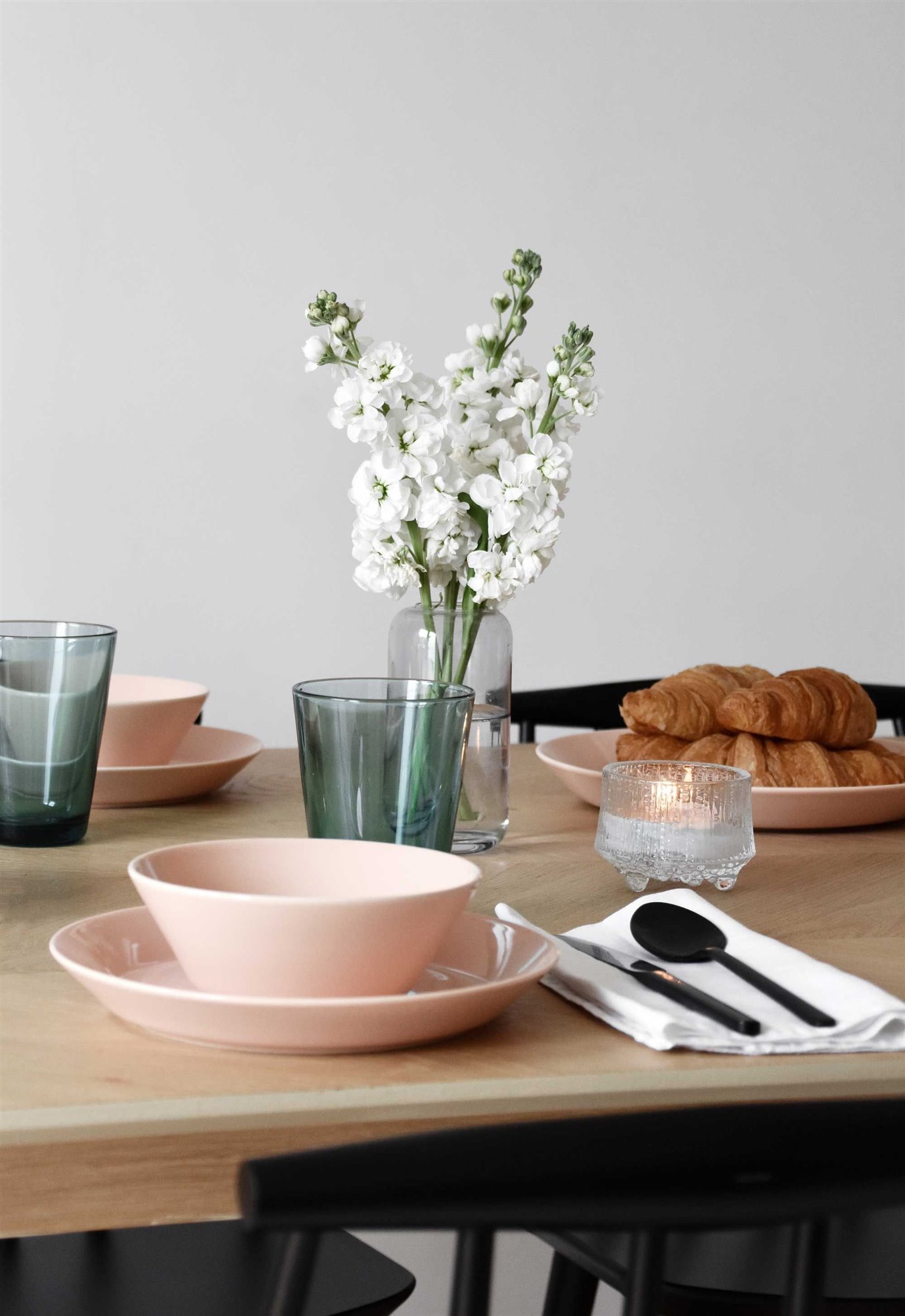 Mesa de desayuno jarron con flores bowls cuencos rosas cubiertos negros