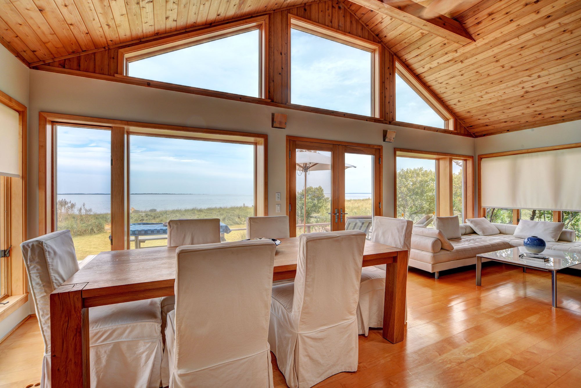 casa de Samanta de Sexo en Nueva York en los Hamptons comedor con sillas con fundas blancas y vistas al mar
