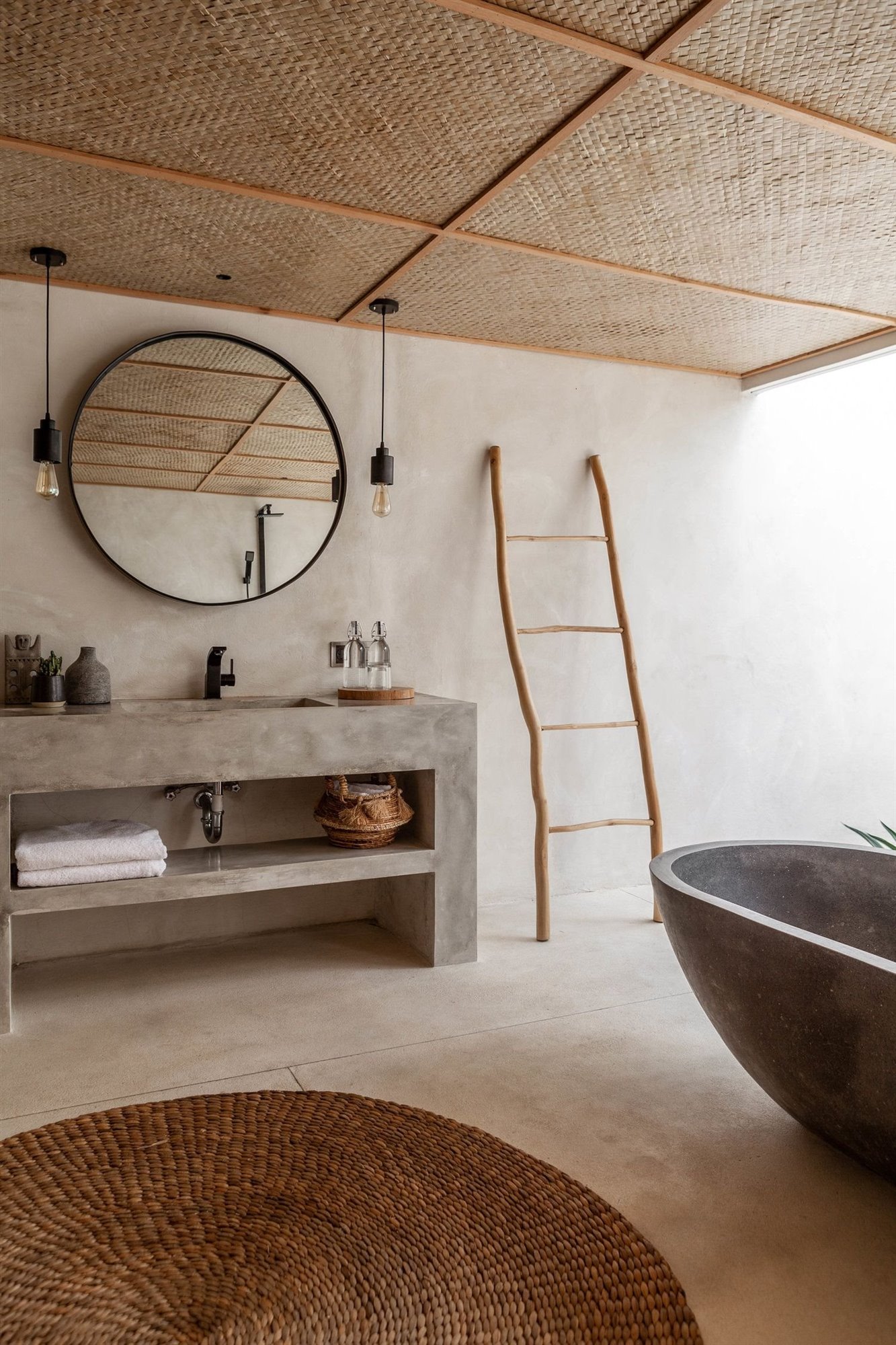Baño con alfombra de fibras naturales y bañera de color gris