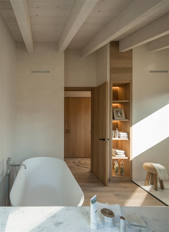 Baño con bañera y suelo de madera