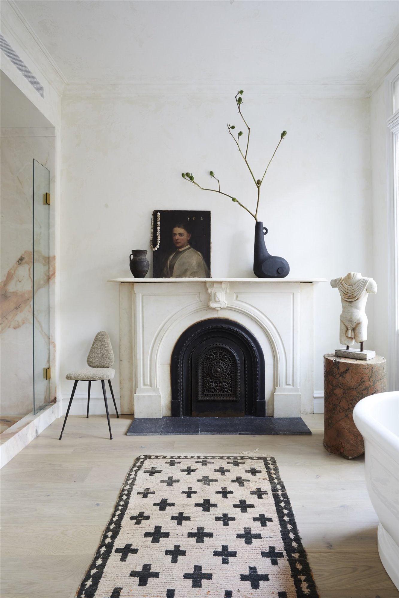 Baño con chimenea y esculturas y cuadros