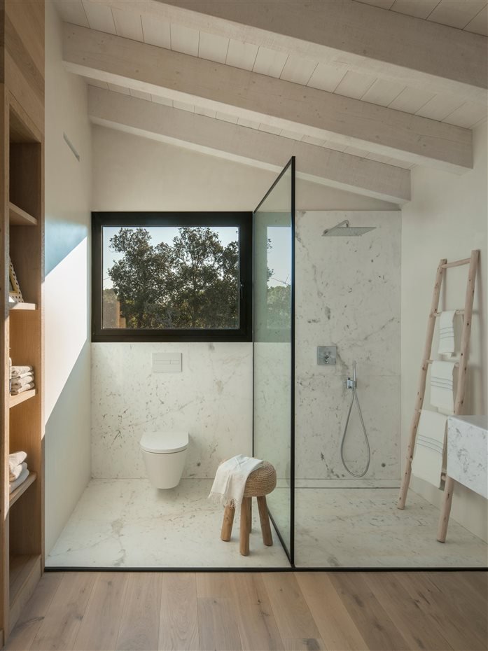 Baño con ducha en una buhardilla suelo de madera y de marmol de color blanco