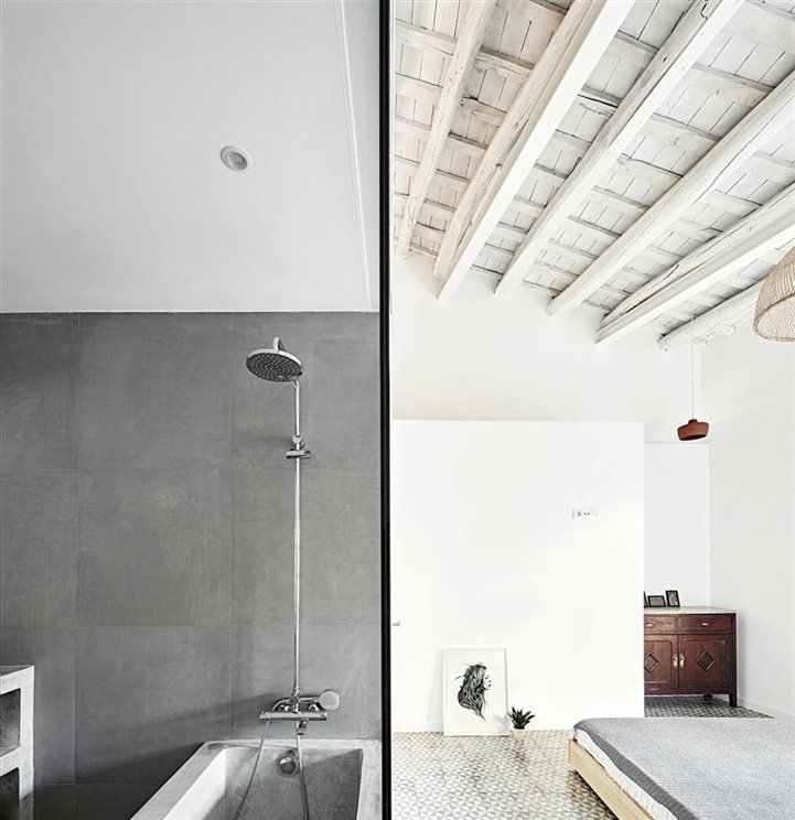 Baño con ducha y vigas de color blanco